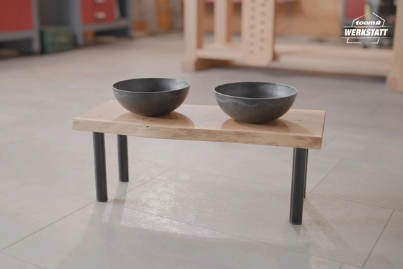 Zwei Futternäpfe auf einem kleinen Holztisch